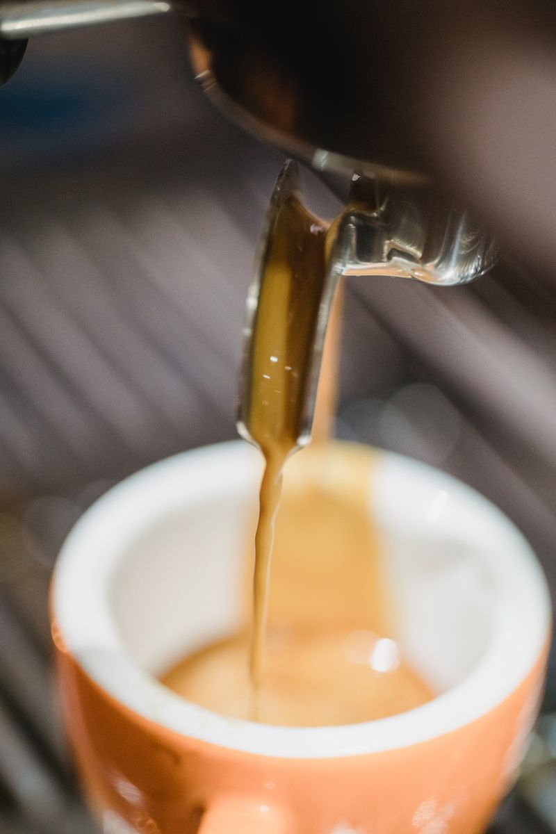 Espresso pouring from a machine into a cup